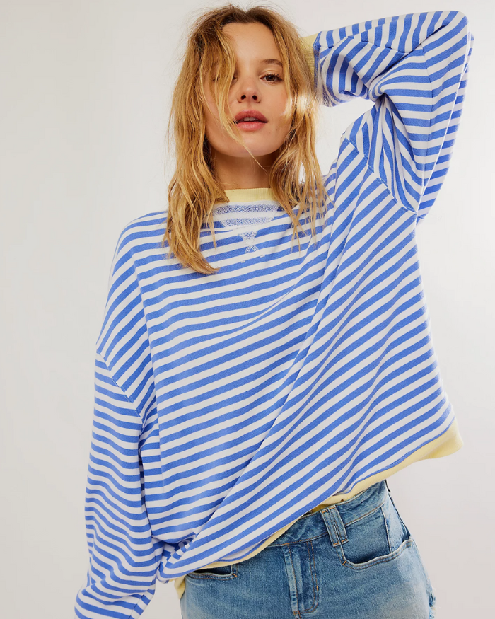 Frau in blau-weiß gestreiftem Pullover und Jeans, lässiger Look, Mode für Damen, trendiger Freizeitstil, modische Kleidung, urbaner Chic.