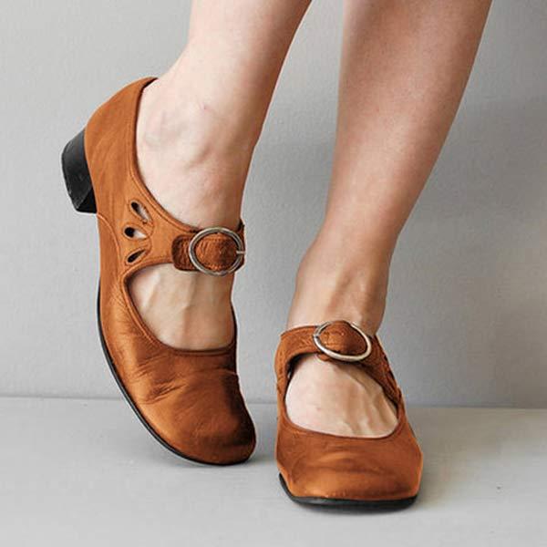 Braune Mary Jane Schuhe mit Riemen und Schnalle, niedriger Absatz, getragen von einer Person. Modische Damenschuhe, bequem und stilvoll.