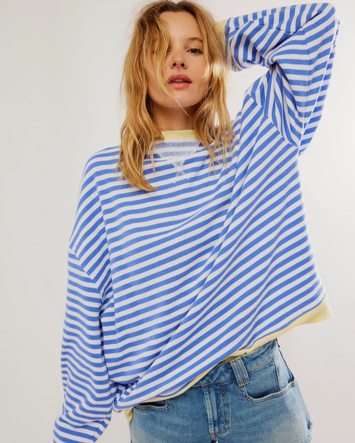 Frau in blau-weiß gestreiftem Pullover und Jeans, lässiger Look, Mode für Damen, trendige Freizeitkleidung, stilvolles Outfit, modische Streifen.