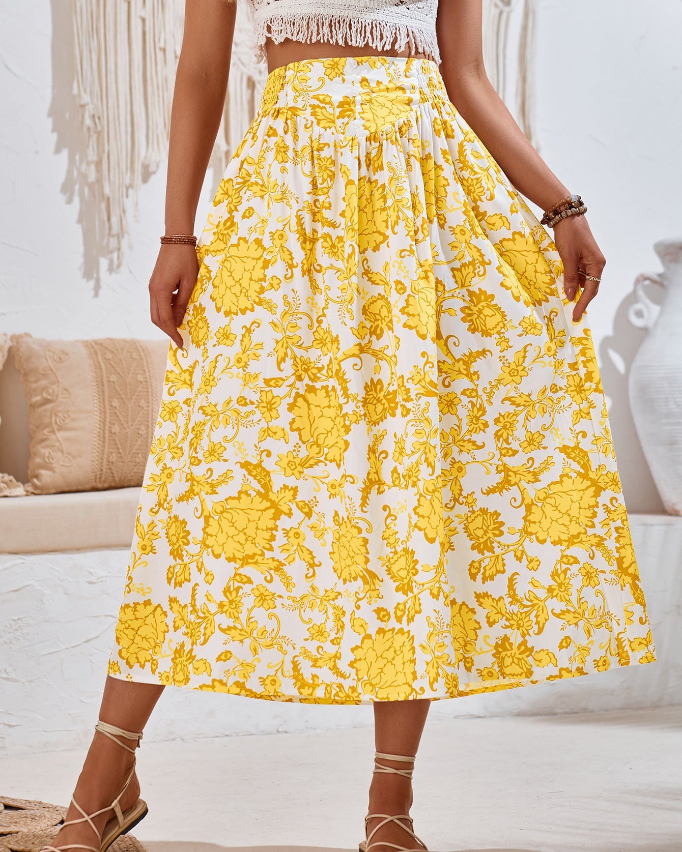 Frau trägt gelben Blumenrock, Sommermode, Boho-Stil, knöchellang, weißer Hintergrund, modische Kleidung, lässiger Look, trendiges Design.