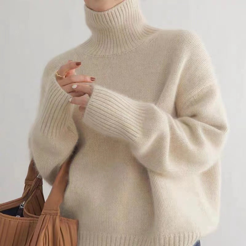 Frau in cremefarbenem Rollkragenpullover hält braune Handtasche. Modetrend, Herbstmode, Strickpullover, Damenbekleidung, eleganter Look.