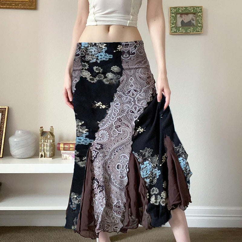 Frau trägt langen, gemusterten Boho-Rock in Schwarz, Blau und Braun. Modetrend, Boho-Chic, Damenmode, stilvoller Look, Wohnzimmer-Hintergrund.