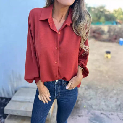 Frau in roter Bluse und blauen Jeans, lässiger Herbstlook, modische Damenbekleidung, Outdoor-Hintergrund, stilvolle Freizeitmode.