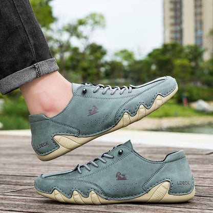 Grüne Freizeitschuhe aus Leder mit markanter Sohle, getragen im Freien. Stilvolle Herrenschuhe, ideal für lässige Outfits und Spaziergänge.