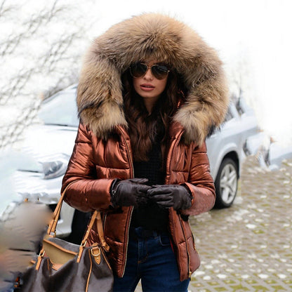 Frau in brauner Daunenjacke mit Fellkapuze, Sonnenbrille und Handschuhen, steht vor einem Auto im Winter. Wintermode, stilvolle Damenbekleidung.