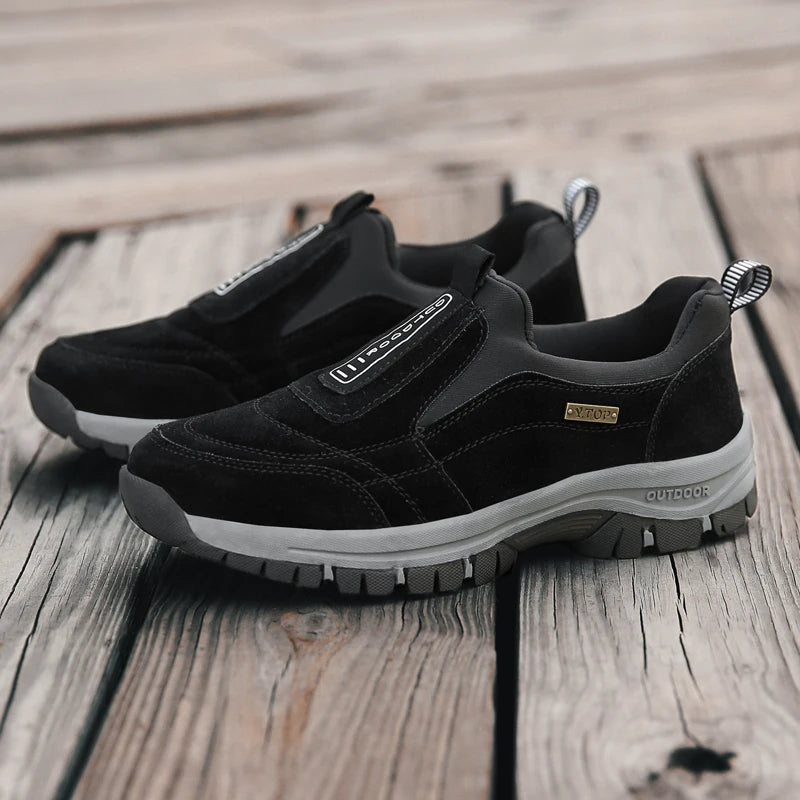 Schwarze Outdoor-Sneaker auf Holzboden, robustes Design, rutschfeste Sohle, ideal für Wandern und Freizeit, Herrenmode, bequeme Passform.