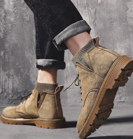 Beige Wildlederstiefel mit dicker Sohle, getragen mit hochgekrempelten Jeans. Modische Damenstiefel für Herbst und Winter.