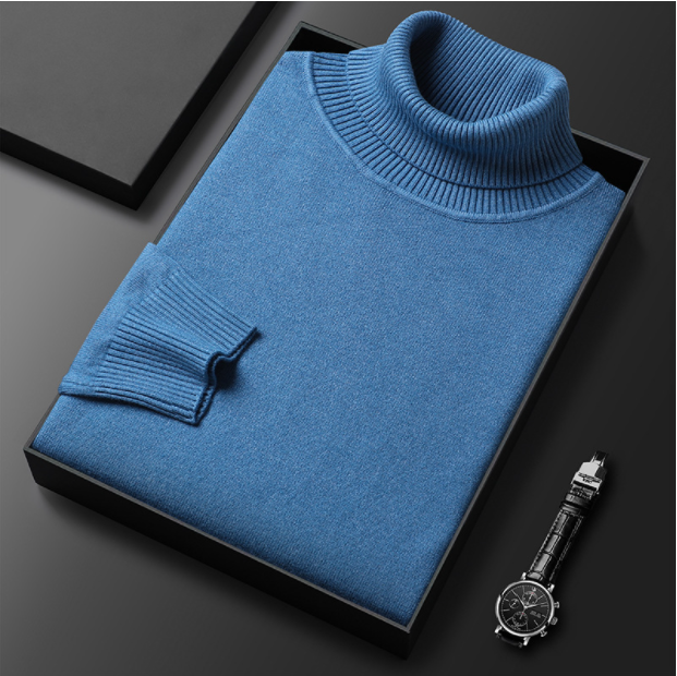 Blauer Rollkragenpullover aus Kaschmir in Geschenkbox, elegant gefaltet, neben einer stilvollen Armbanduhr. Luxuriöse Modeaccessoires.