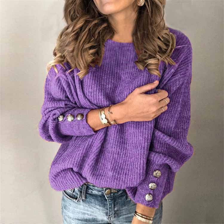 Frau in lila Strickpullover mit Knöpfen an den Ärmeln, trägt Jeans und Armbänder. Modetrend, Herbstmode, Damenbekleidung.