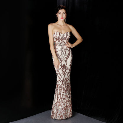 Frau in eleganter, schulterfreier Abendkleid mit aufwendigem Muster, posiert vor schwarzem Hintergrund. Perfekt für Gala, Ball oder Abendveranstaltung.