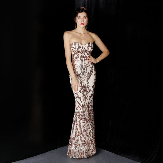Frau in eleganter, schulterfreier Abendkleid mit aufwendigem Muster, posiert vor schwarzem Hintergrund. Perfekt für Gala, Ball oder Abendveranstaltung.