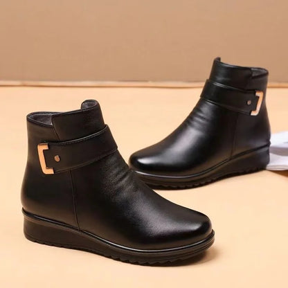 Schwarze Damenstiefeletten aus Leder mit flachem Absatz und dekorativer Schnalle, ideal für Herbstmode und bequemen Alltagsstil.
