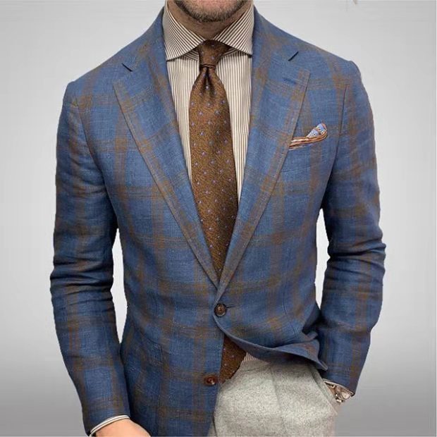 Eleganter Mann im karierten blauen Anzug mit brauner Krawatte und Einstecktuch, gestreiftem Hemd, modisch, stilvoll, Business-Outfit.