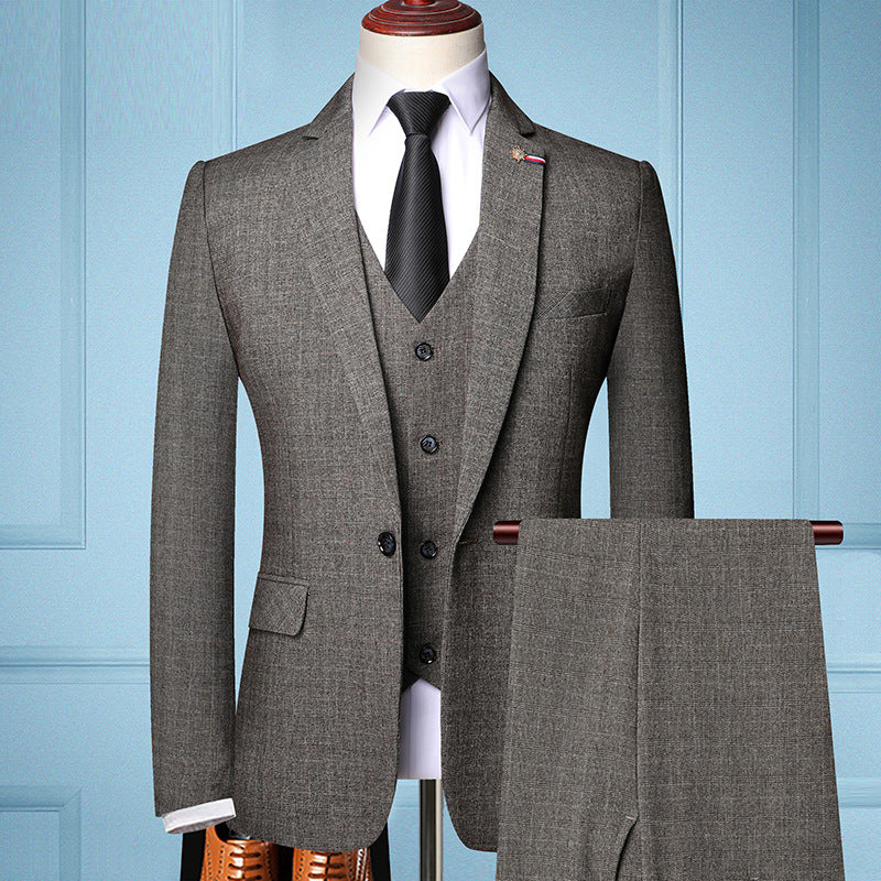 Grauer Herrenanzug mit Weste und Krawatte auf Schneiderpuppe vor blauer Wand. Eleganter Business-Look, ideal für formelle Anlässe.