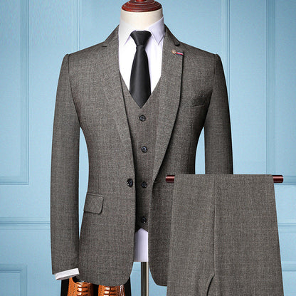 Grauer Herrenanzug mit Weste und Krawatte auf Schneiderpuppe vor blauer Wand. Eleganter Business-Look, ideal für formelle Anlässe.