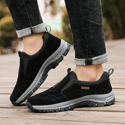 Schwarze Outdoor-Sneaker für Herren, rutschfeste Sohle, bequemes Design, ideal für Wandern und Freizeit, getragen mit hochgekrempelten Jeans.