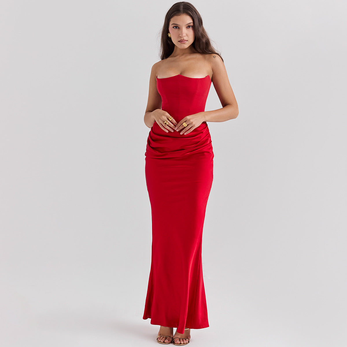Frau in elegantem, schulterfreiem roten Abendkleid, bodenlang, mit drapiertem Design. Perfekt für formelle Anlässe und Abendveranstaltungen.