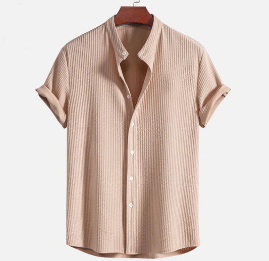Beiges Herrenhemd mit kurzen Ärmeln, Stehkragen und Knopfleiste, aus strukturiertem Stoff. Ideal für Sommermode und Freizeitkleidung.