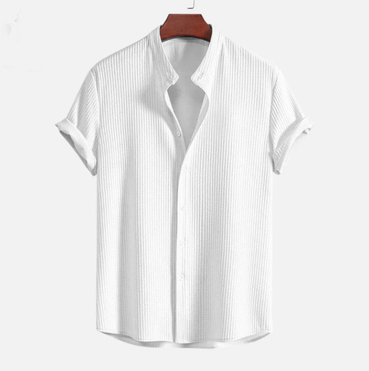 Weißes Herrenhemd mit Stehkragen, kurzärmelig, aus Baumwolle, auf Holzkleiderbügel. Modernes Design, ideal für Sommermode und Freizeitkleidung.