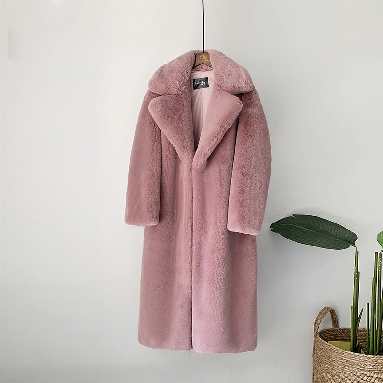 Rosa Kunstpelzmantel, lang, mit breitem Kragen, hängt an weißer Wand. Modetrend, Wintermantel, stilvoll, elegant, luxuriös, Damenbekleidung.