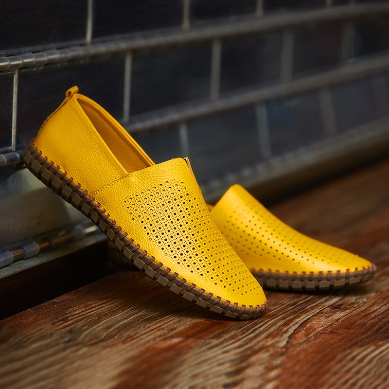 Gelbe, perforierte Lederschuhe für Herren auf Holzboden, ideal für Sommermode. Bequeme, atmungsaktive Slipper mit rutschfester Sohle.