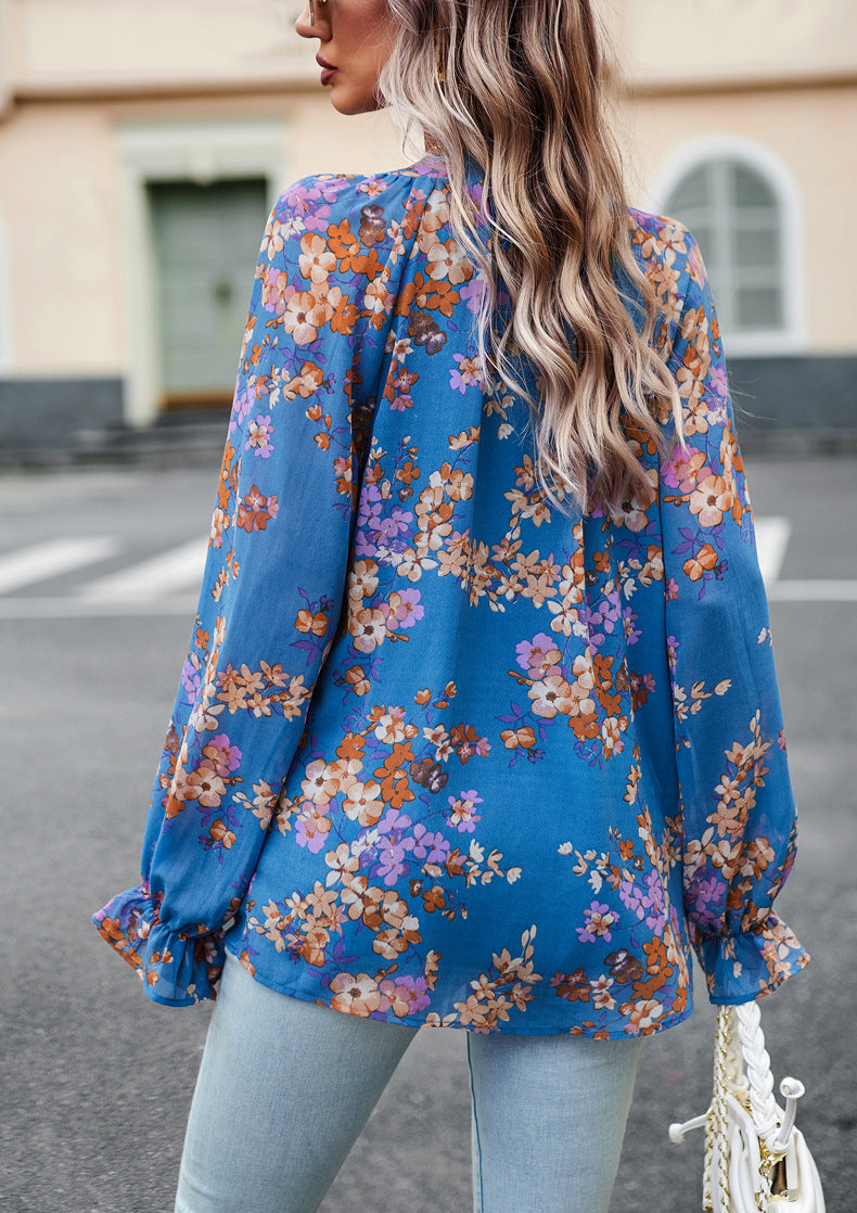 Frau in blauer, geblümter Bluse und Jeans auf Straße. Modetrend, Damenmode, florales Design, lässiger Stil, Herbstmode.