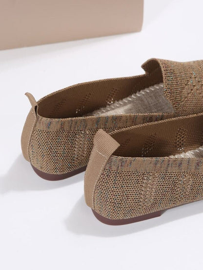 Beige Damen-Ballerinas aus Strickstoff mit rutschfester Sohle, seitlicher Naht und dezentem Glitzereffekt auf weißem Hintergrund.