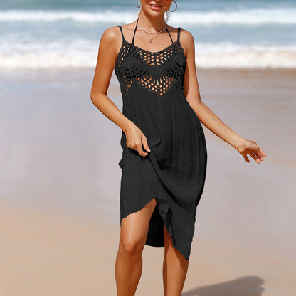 Frau in schwarzem Strandkleid mit Häkelmuster am Meer. Sommermode, Strandkleid, Damenbekleidung, Urlaub, Strandoutfit.