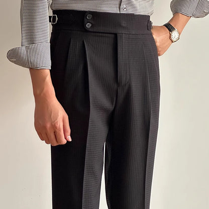 Mann in eleganter, schwarzer Anzughose mit hoher Taille und Knöpfen, trägt kariertes Hemd und Armbanduhr. Businessmode, Herrenbekleidung.