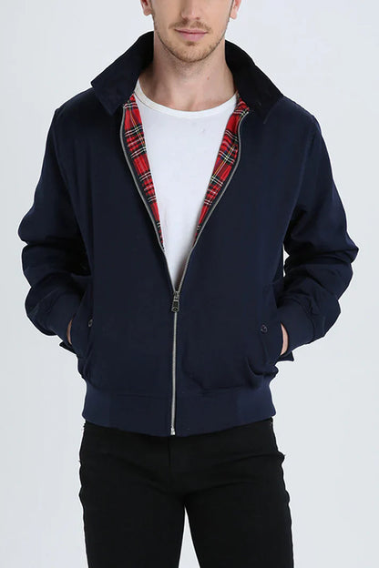 Mann trägt dunkelblaue Harrington-Jacke mit rotem Karofutter, weißem T-Shirt und schwarzer Hose. Modische Herrenbekleidung, lässiger Stil.