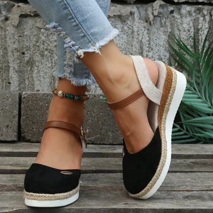 Damen-Sommerschuhe mit Keilabsatz, schwarzem Wildleder, braunen Riemen und geflochtener Sohle. Perfekt für Freizeitmode und sommerliche Outfits.