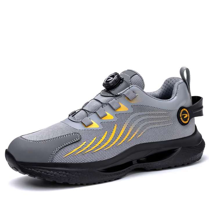 Grauer Sportschuh mit gelben Akzenten, atmungsaktivem Mesh-Obermaterial, Drehverschluss und rutschfester Sohle. Ideal für Laufen und Fitness.