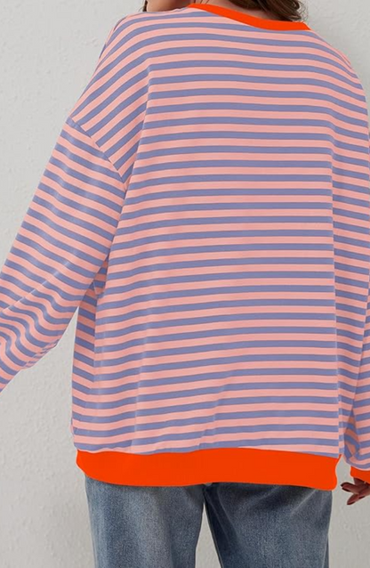 Frau in gestreiftem Pullover, rosa und lila Streifen, orange Bündchen, lässiger Stil, modische Damenbekleidung, Rückansicht.