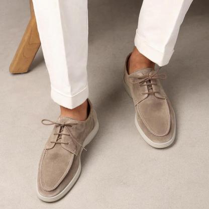 Herren Wildleder-Schnürschuhe in Beige, kombiniert mit weißen Hosen. Elegante Freizeitschuhe, ideal für stilvolle, moderne Outfits.