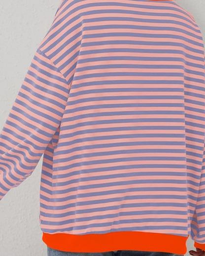 Gestreiftes Langarmshirt in Rosa und Blau mit orangefarbenem Saum, modisches Design, lässiger Stil, ideal für trendige Freizeitoutfits.