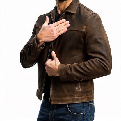 Mann in brauner Lederjacke, Reißverschluss halb geöffnet, Hand auf Brust. Modische Herrenbekleidung, lässiger Stil, Jeans kombiniert.