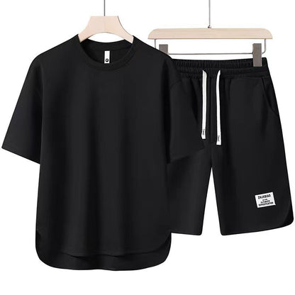 Schwarzes T-Shirt und Shorts Set auf Kleiderbügeln, sportlich, lässig, ideal für Sommermode, Herrenbekleidung, atmungsaktiv, bequem.
