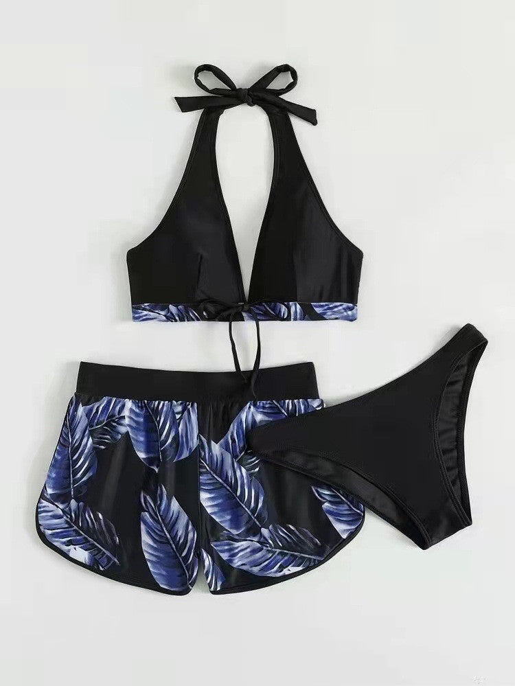 Dreiteiliger Badeanzug für Damen, bestehend aus schwarzem Neckholder-Top, blauen Blättermuster-Shorts und passendem Bikinihöschen.