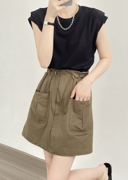 Frau in schwarzem T-Shirt und olivgrünem Rock mit Taschen, modisches Outfit, Sommermode, lässiger Stil, minimalistische Kleidung.