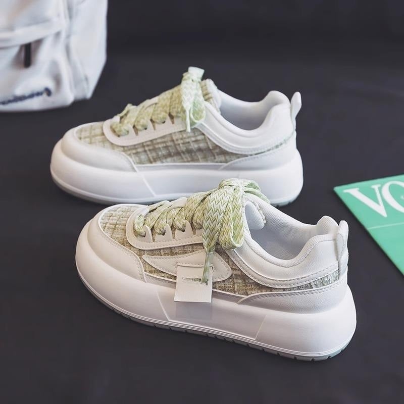 Grüne Sneaker mit dicker Sohle und kariertem Muster auf schwarzem Hintergrund. Modische Turnschuhe, trendiges Design, bequeme Freizeitschuhe.