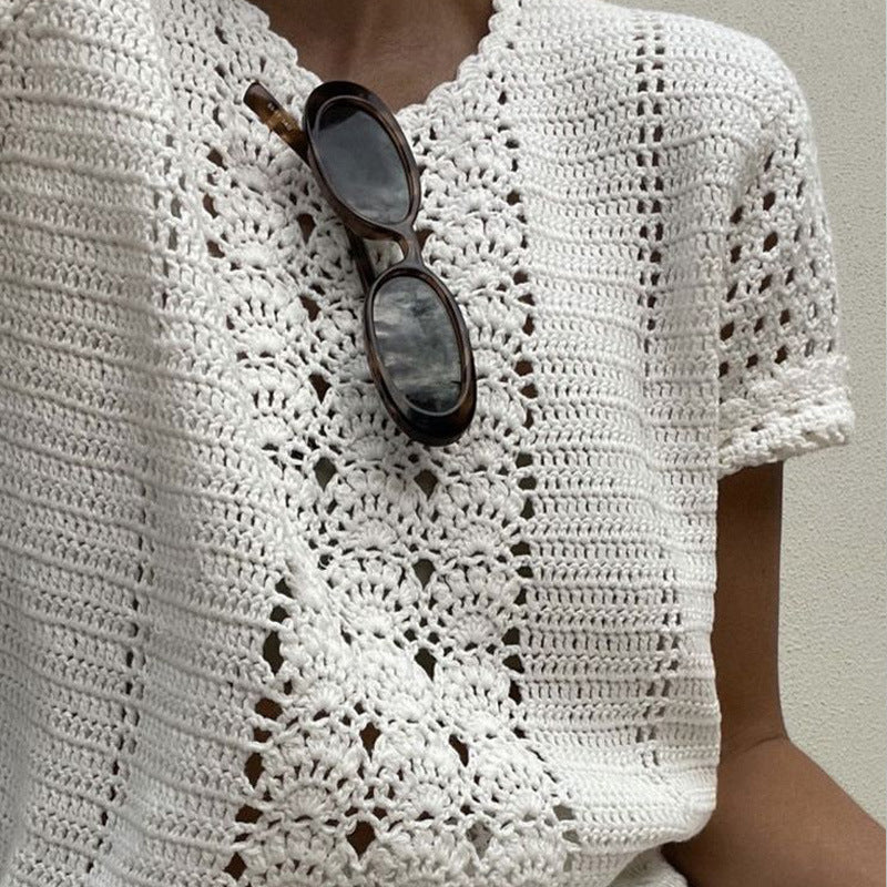 Weiße gehäkelte Bluse mit detailliertem Muster, kombiniert mit einer Sonnenbrille. Perfekt für Sommermode und handgefertigte Kleidung.