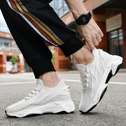 Weiße Sportschuhe für Herren auf städtischer Straße, getragen mit schwarzer Hose mit Streifen. Moderne Sneaker, ideal für Laufen und Freizeit.