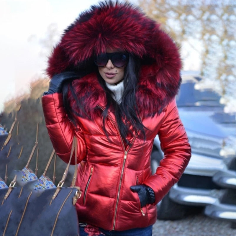 Frau in roter Daunenjacke mit Fellkapuze, Sonnenbrille und Handschuhen im Winter. Modetrend, Wintermode, Outdoor-Bekleidung.