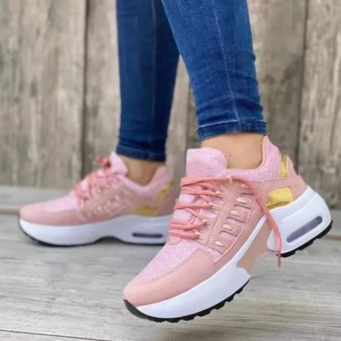 Damen Sneaker in Rosa mit goldenen Akzenten, getragen von Person in blauen Jeans. Modische Sportschuhe, ideal für Freizeit und Sport.