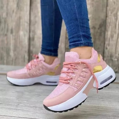 Damen Sneaker in Rosa mit goldenen Akzenten, getragen von Person in blauen Jeans. Modische Sportschuhe, ideal für Freizeit und Sport.