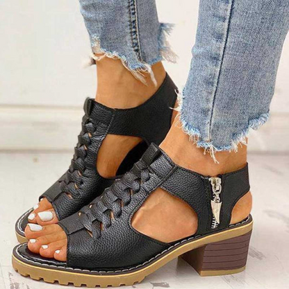 Schwarze Sandaletten mit Blockabsatz und Reißverschluss, getragen mit ausgefransten Jeans. Modische Sommerschuhe für Damen, ideal für Freizeitoutfits.