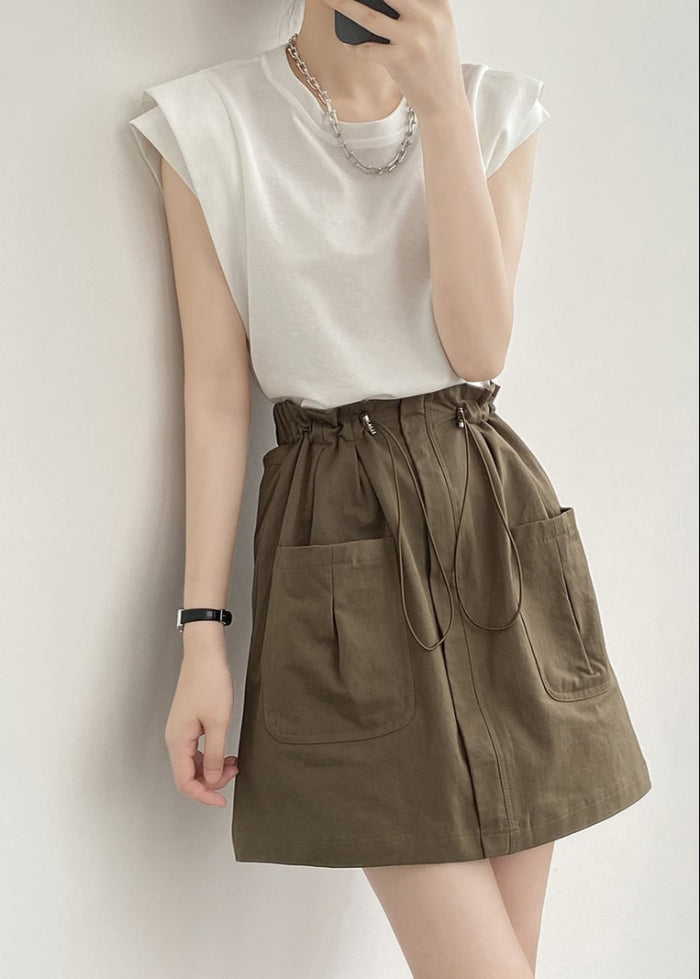 Frau in weißem T-Shirt und olivgrünem Rock mit Taschen, modisches Outfit, Sommermode, lässiger Stil, minimalistisch, trendige Damenbekleidung.