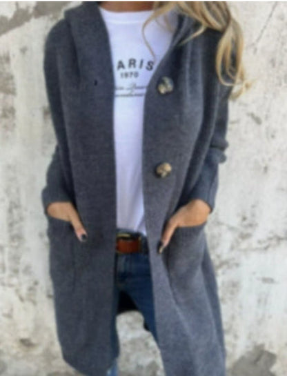 Frau in grauem Strickmantel mit Kapuze, trägt weißes Paris-T-Shirt und Jeans. Modischer Herbst-Look, lässig und stilvoll.