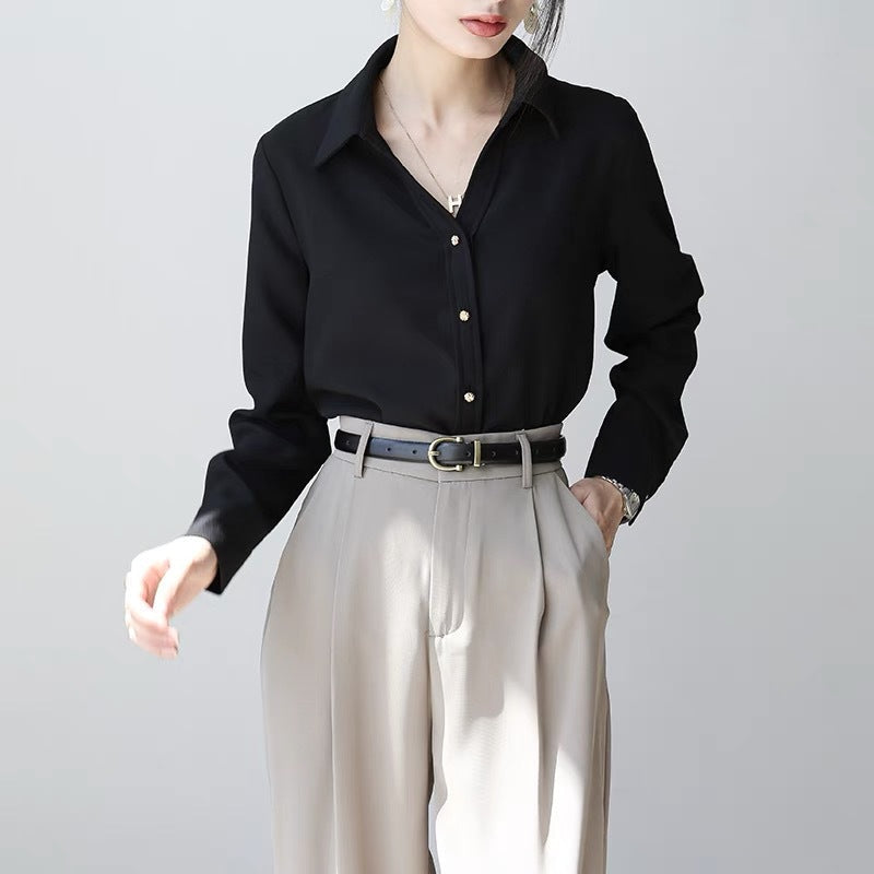 Frau in eleganter schwarzer Bluse und beigen Hose, modisch gekleidet, Business-Look, minimalistisch, stilvoll, moderne Damenmode.
