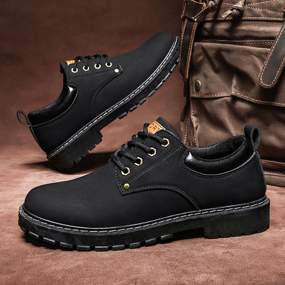 Schwarze Herrenschuhe mit robusten Sohlen, ideal für Outdoor-Aktivitäten. Stilvoll und langlebig, neben einer braunen Ledertasche platziert.